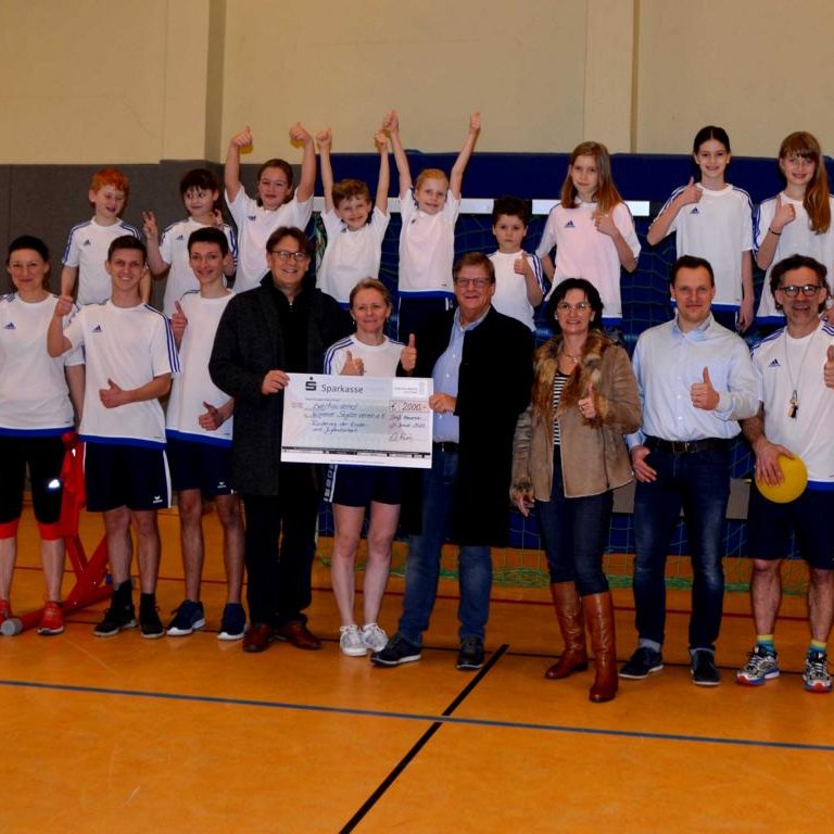 Eine Gruppe Menschen steht in Sportkleidung in reihe und Jubelt , sie erhalten gerade einen Spende