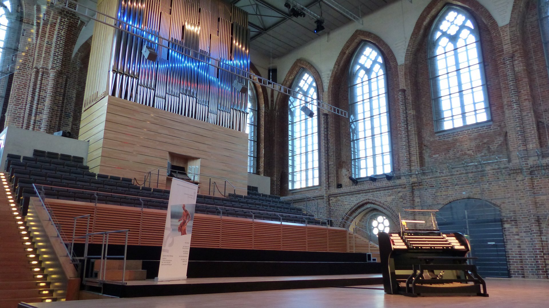 Zu sehen ist eine Orgelkirche mit einem Podium und Sitzbänken